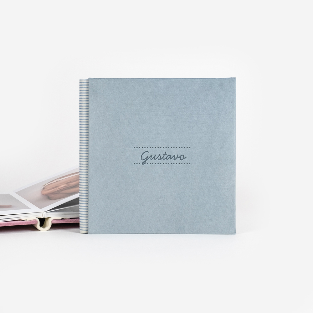 Álbum fotográfico de tapa azul claro con nombre grabado "Gustavo"