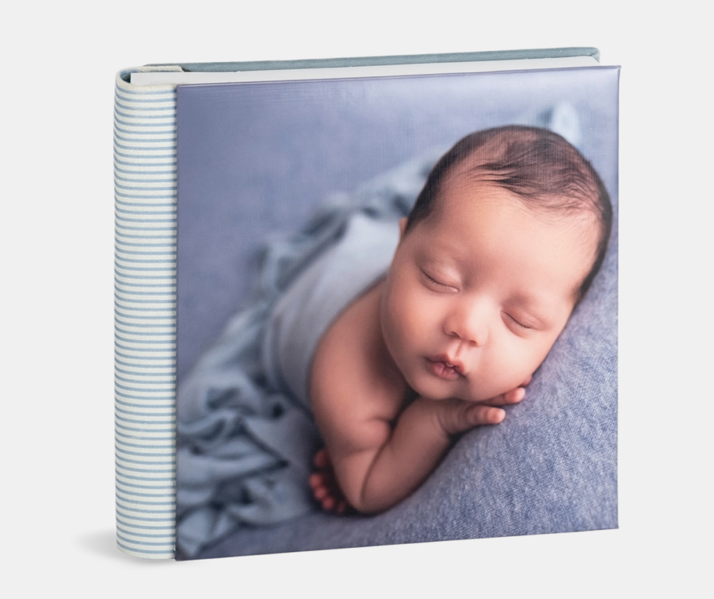 Álbum fotográfico de tapa azul con fotografía de recién nacido dormido