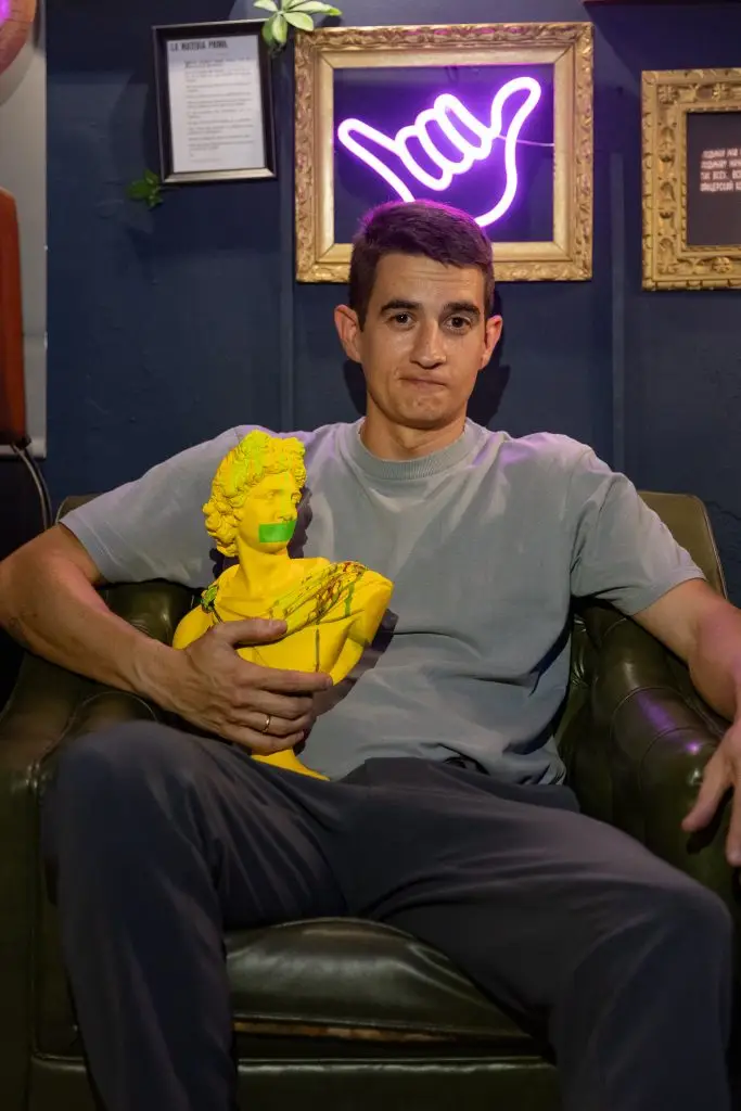 Joven sentado en sofá con peluche amarillo