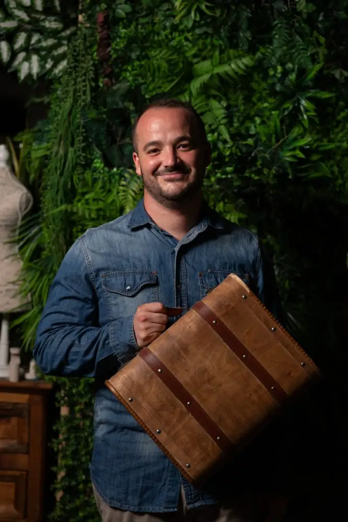 Hombre sonriendo sosteniendo un álbum antiguo